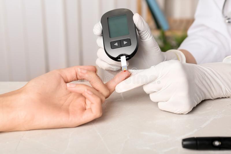 Doctor Checking Blood Sugar Level With Glucometer Stock Photo
